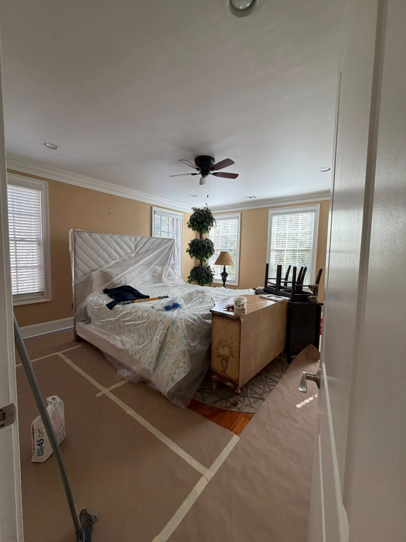 Bedroom with a bed, nightstand, and windows, captured in a wide-angle view.