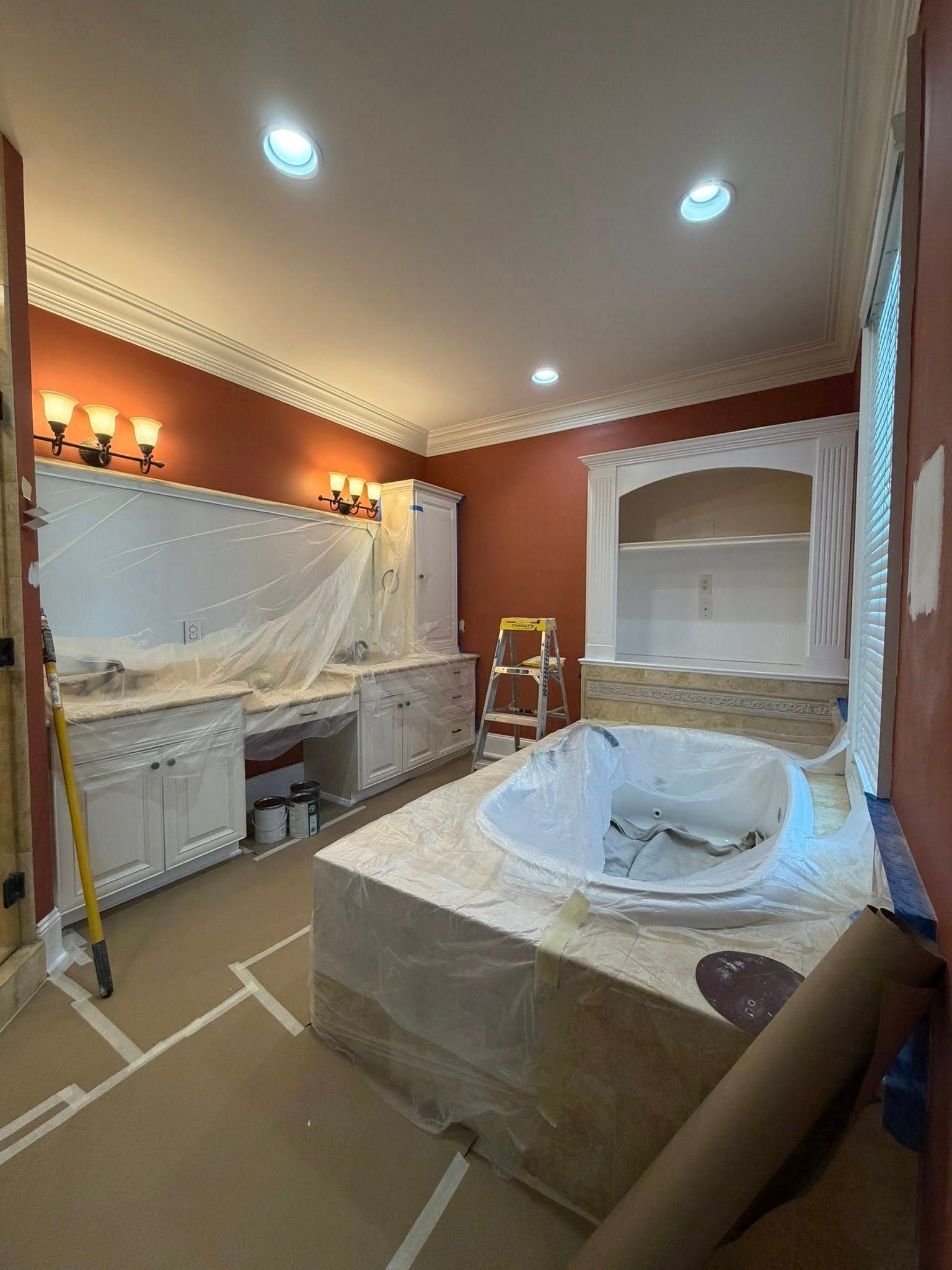 Elegant bathroom under renovation with marble vanity, freestanding tub, and recessed ceiling lights