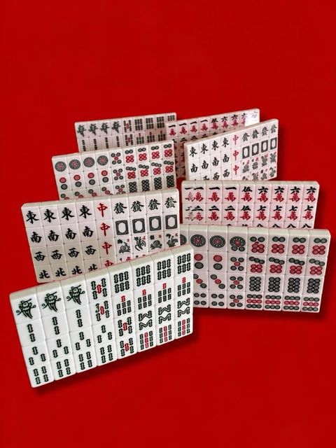 Mahjong tiles arranged in a fan against a bright red background.