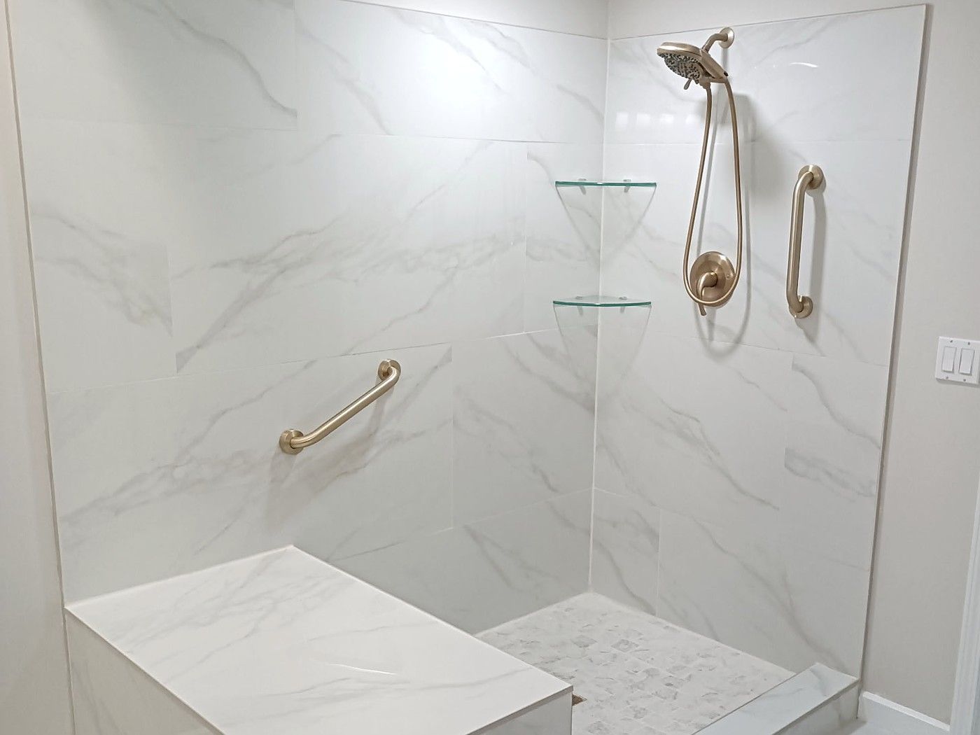Walk-in shower with built-in bench, grab bars and handheld shower from a Lakeview bathroom remodel