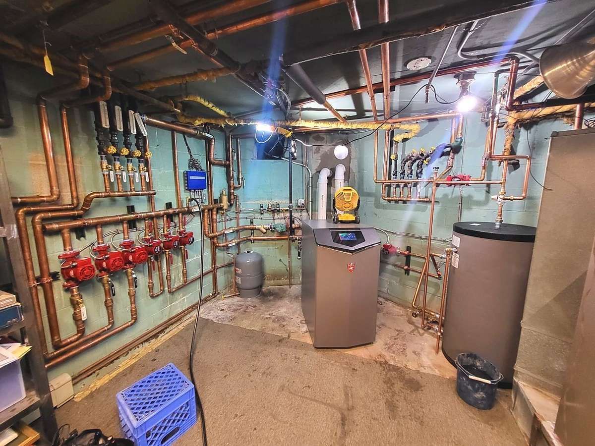 High-efficiency boiler, indirect water heater and zoned copper piping installed by Lakeview in a basement boiler room