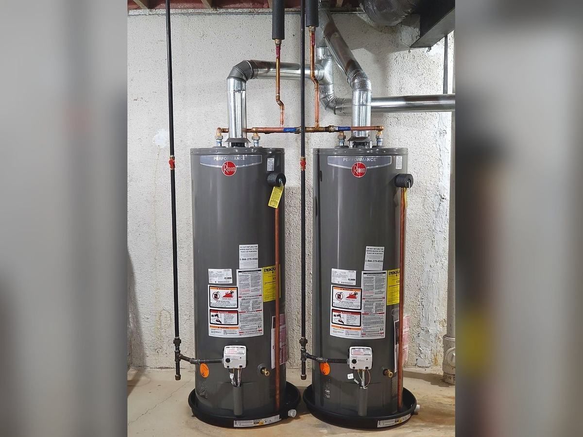Two new Rheem gas water heaters with drain pans and new venting in a basement, installed by Lakeview