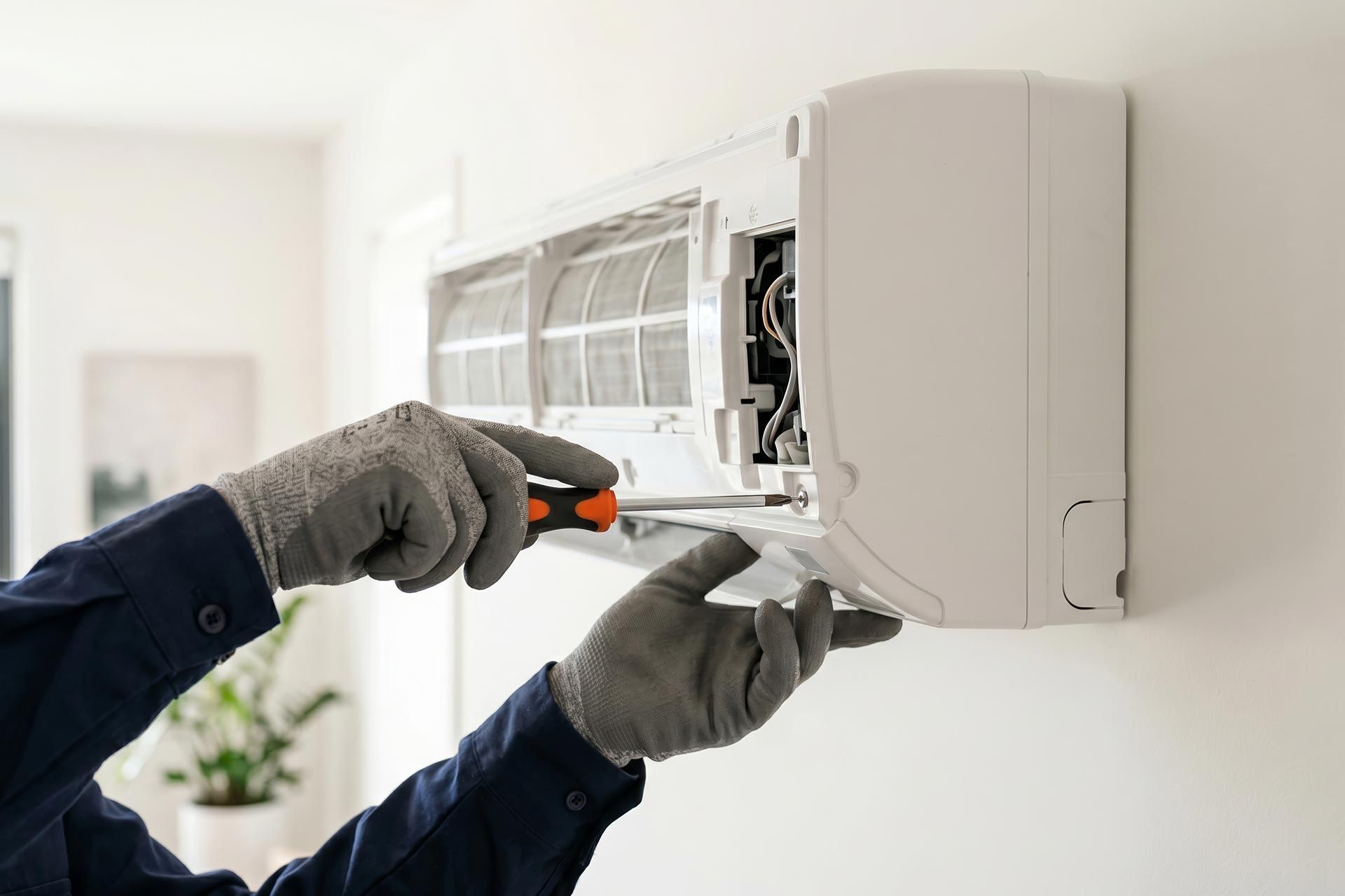 Technician repairing air conditioner with screwdriver. Man fixing home climate control system. Professional HVAC maintenance and installation service. Equipment service and repair concept. Technician repairing air conditioner with screwdriver. Man fixing home climate control system. Professional HVAC maintenance and installation service. Equipment service and repair concept.