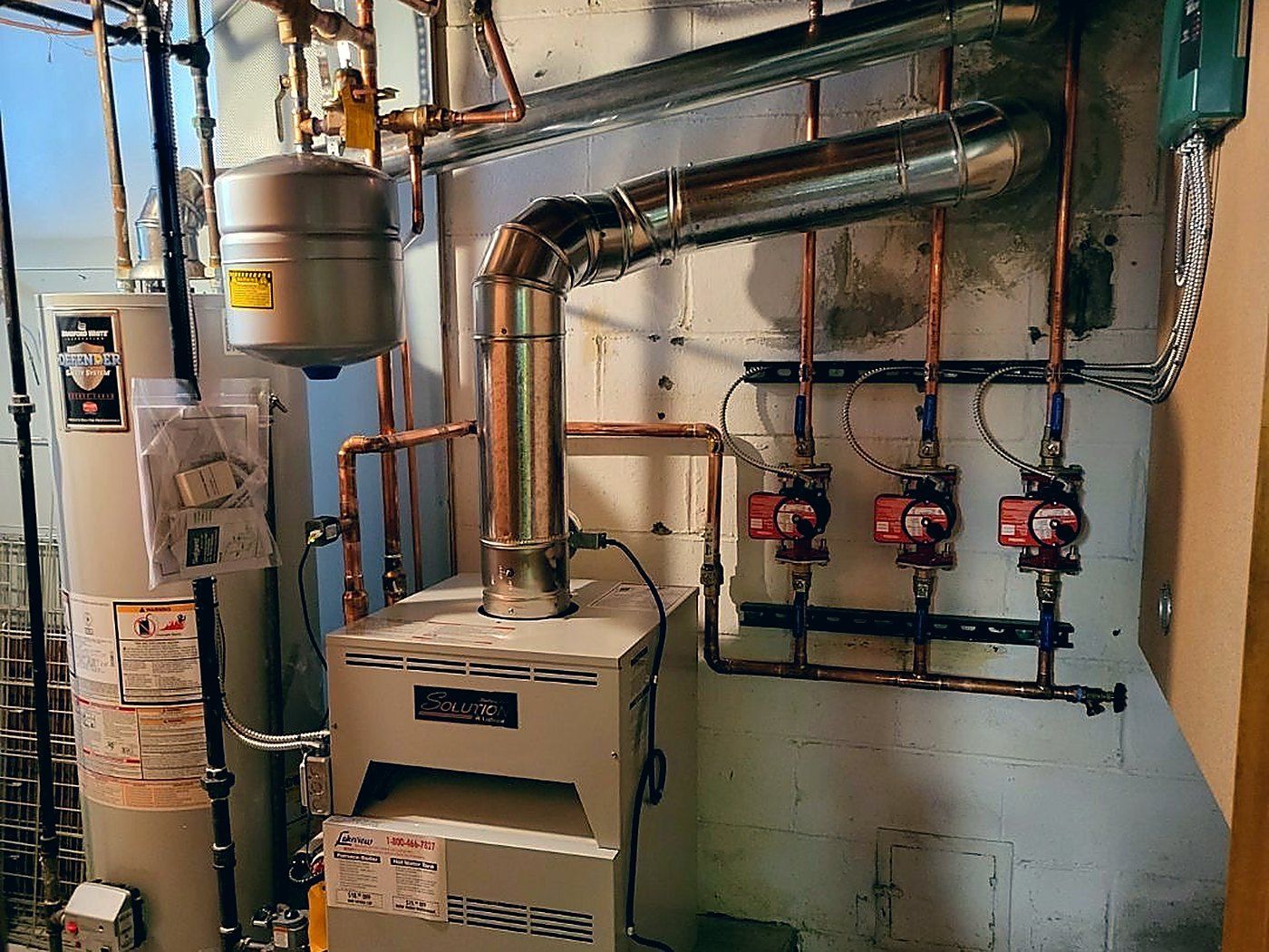 Gas boiler, flue and copper hot water piping installed in a basement mechanical room by Lakeview in Warren, MI