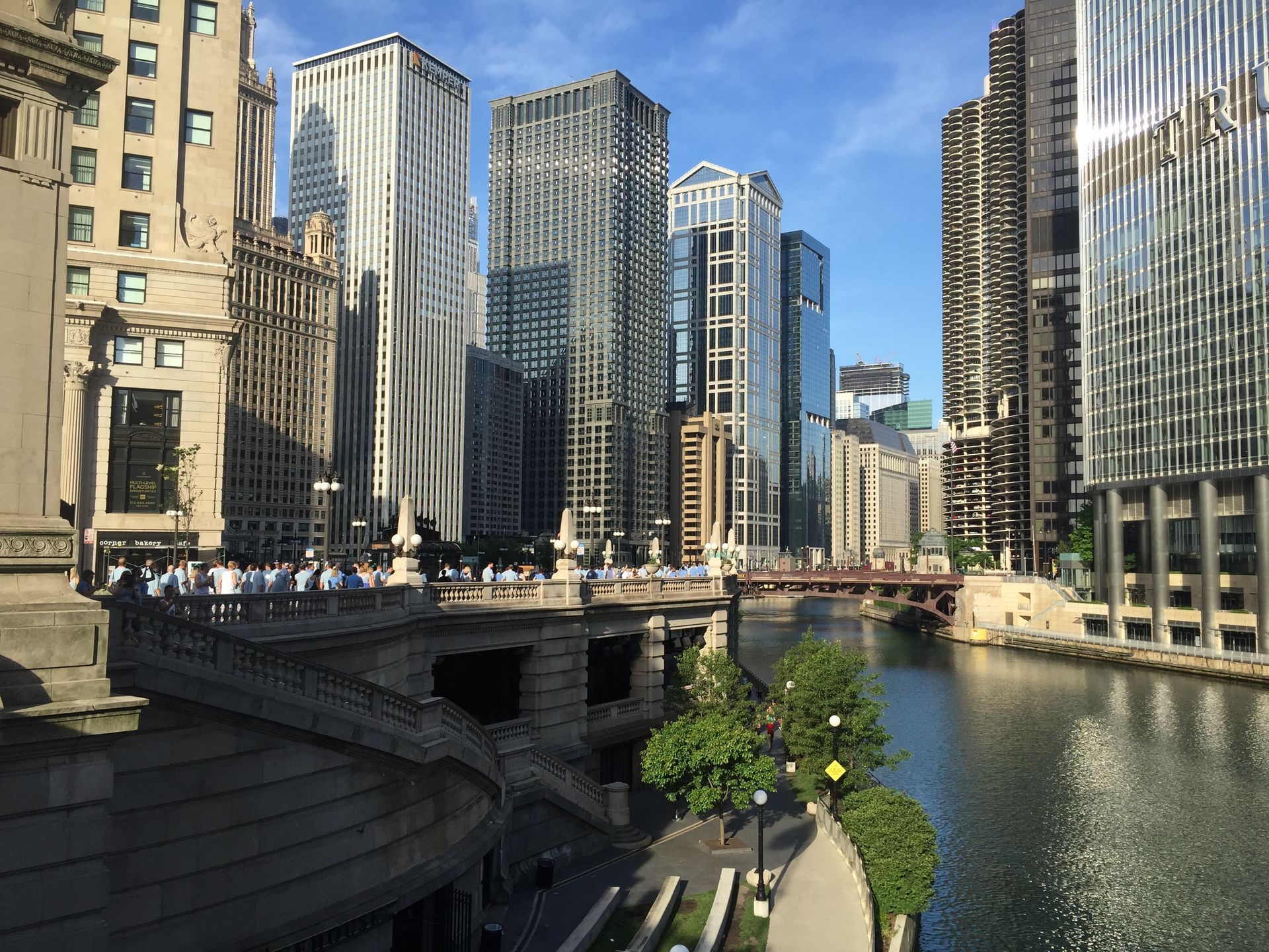 Chicago River skyline with high-rise buildings, bridge, and calm water on a sunny day