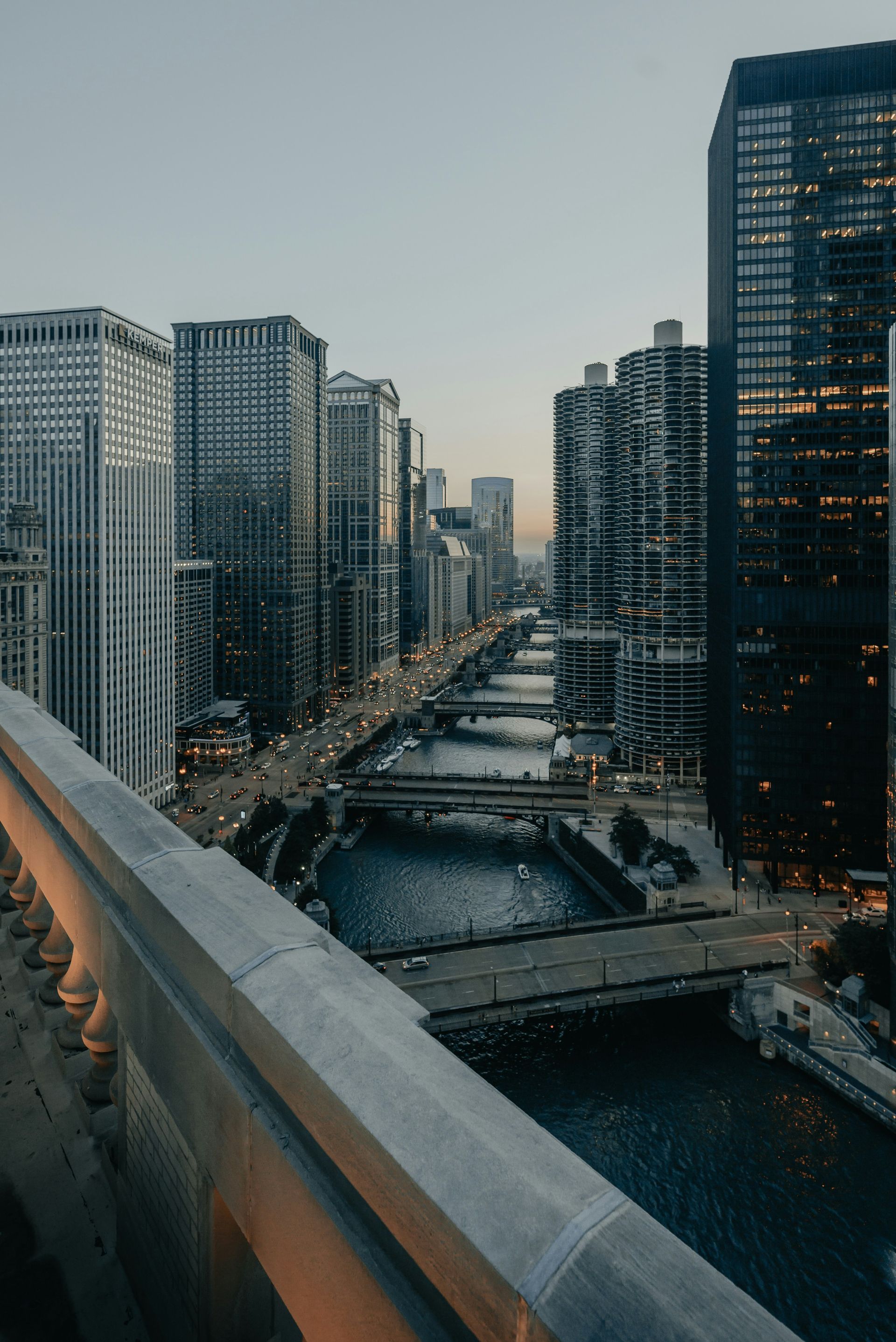 City river canal lined with tall buildings at dusk, viewed from a bridge.