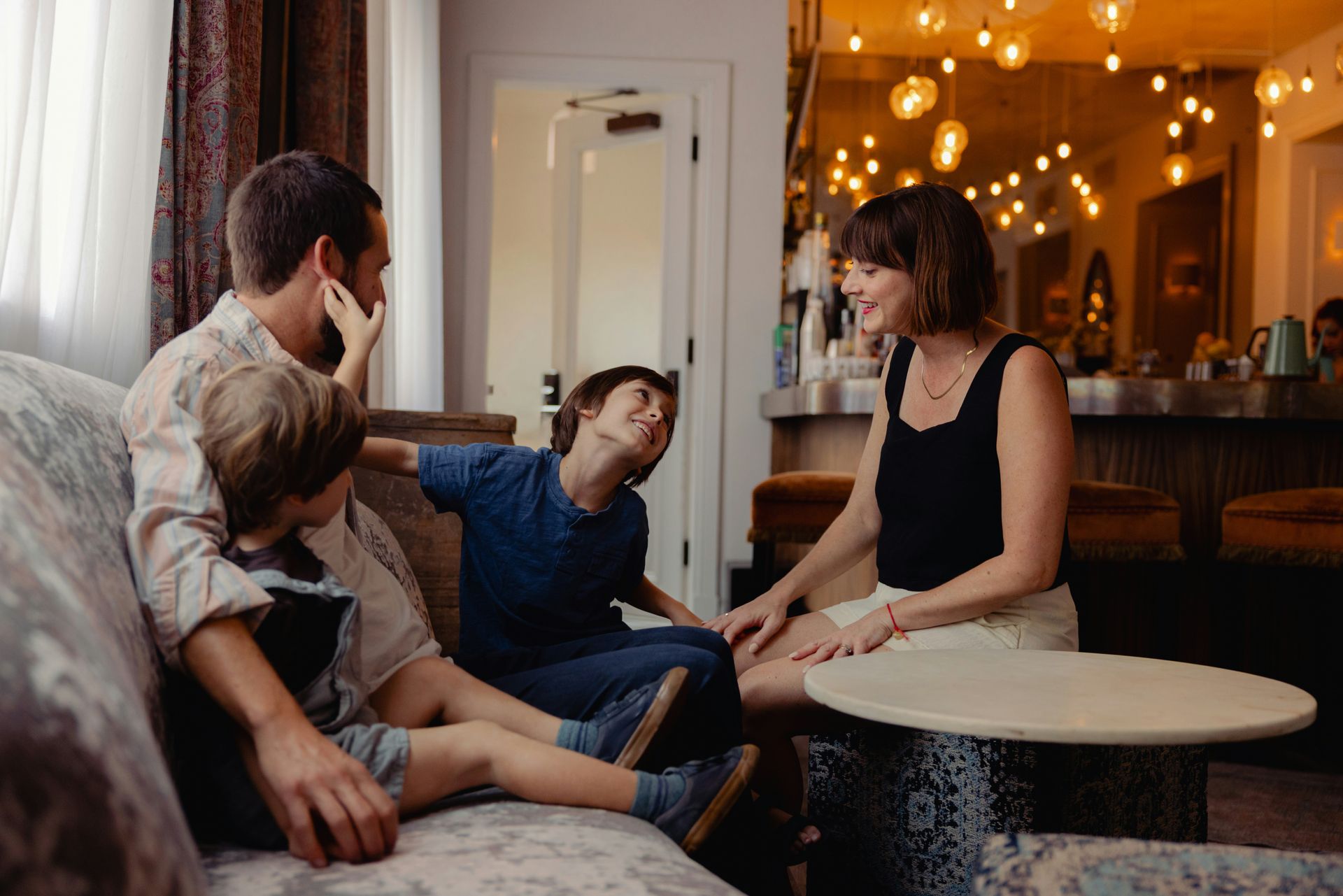 Group chatting in a cozy cafe, with warm string lights and a small round table.