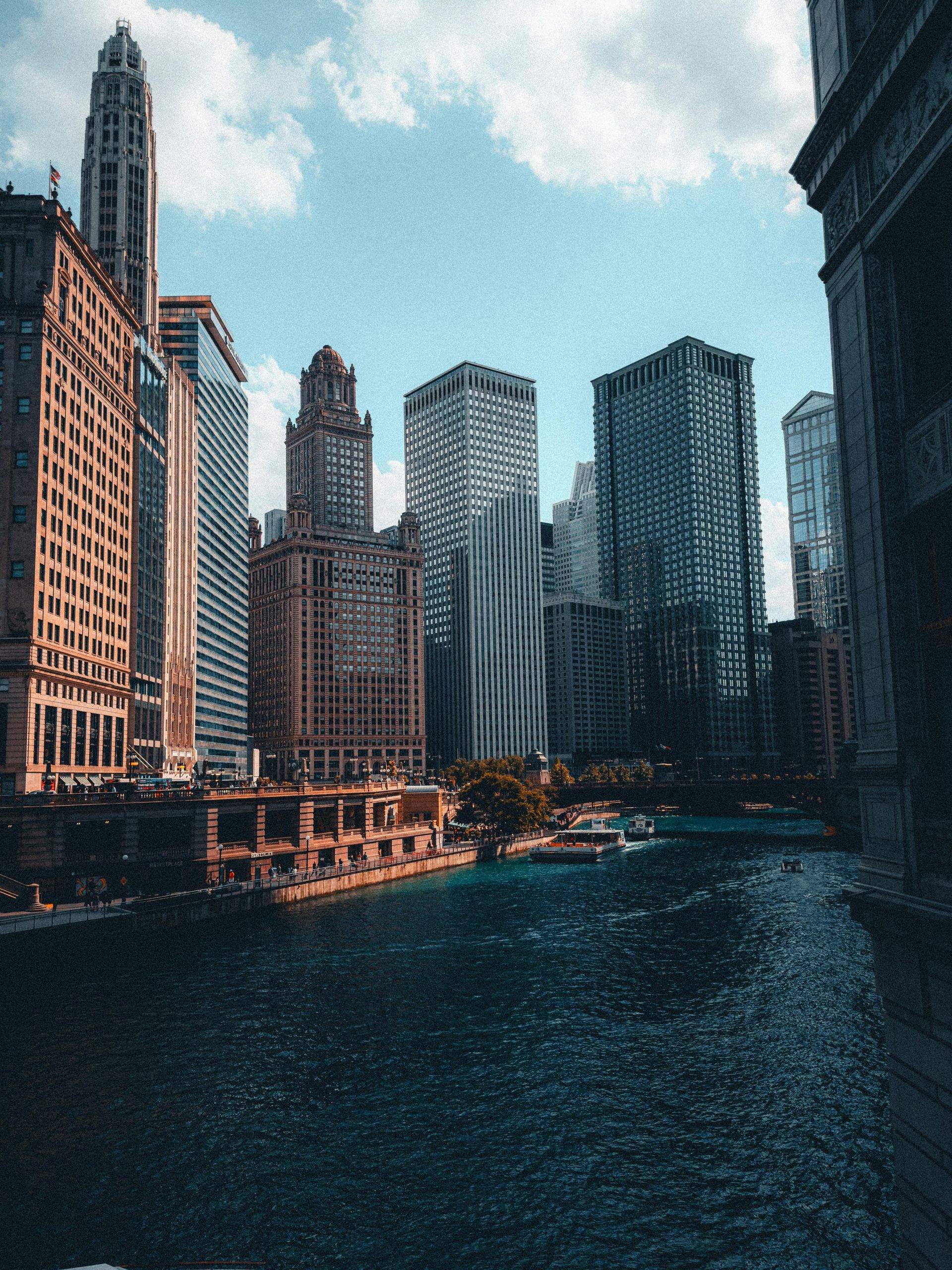 Chicago riverfront with tall downtown skyscrapers under a cloudy sky