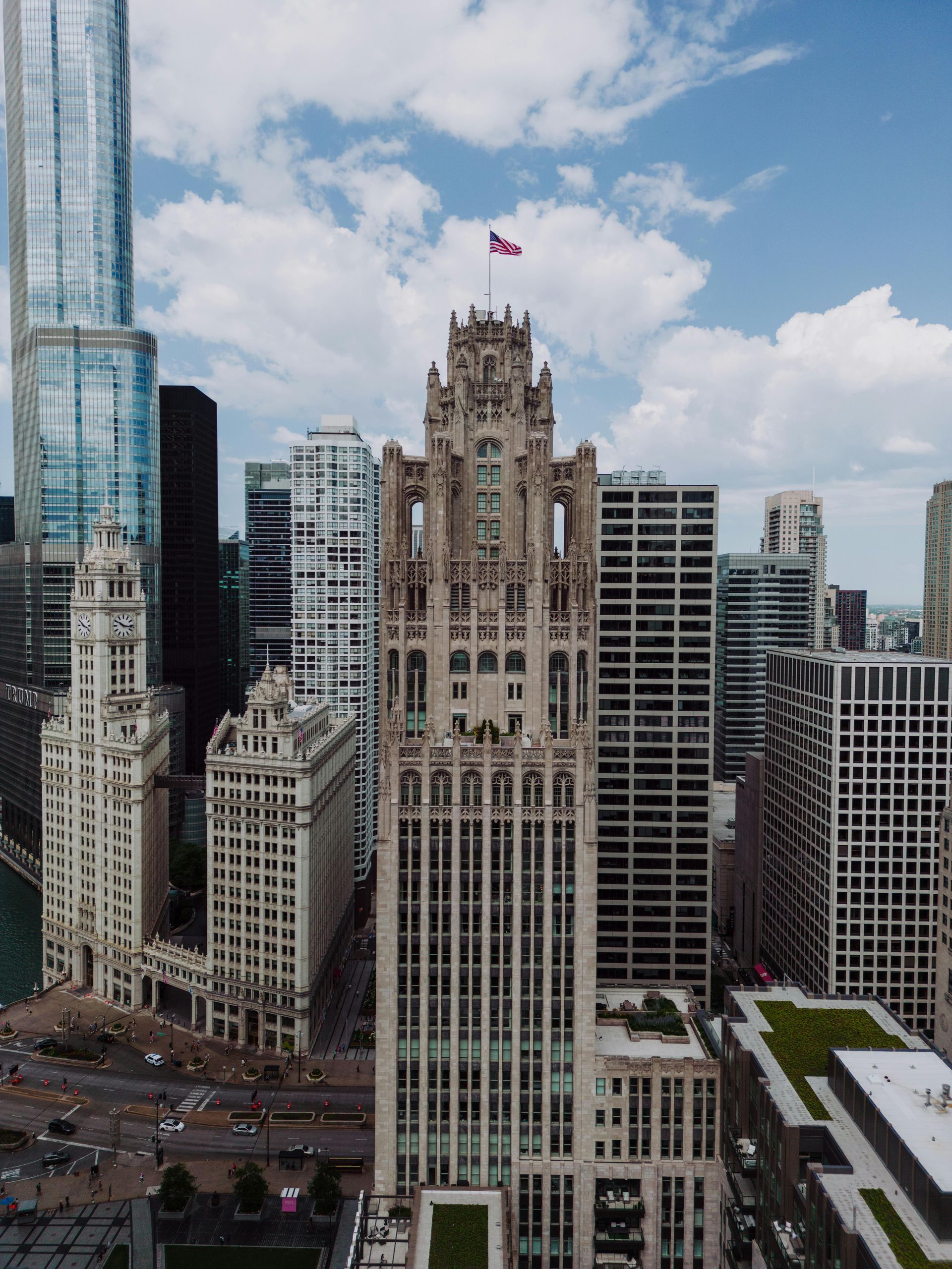 Chicago skyscrapers, including the Tribune Tower, rise under a partly cloudy sky.