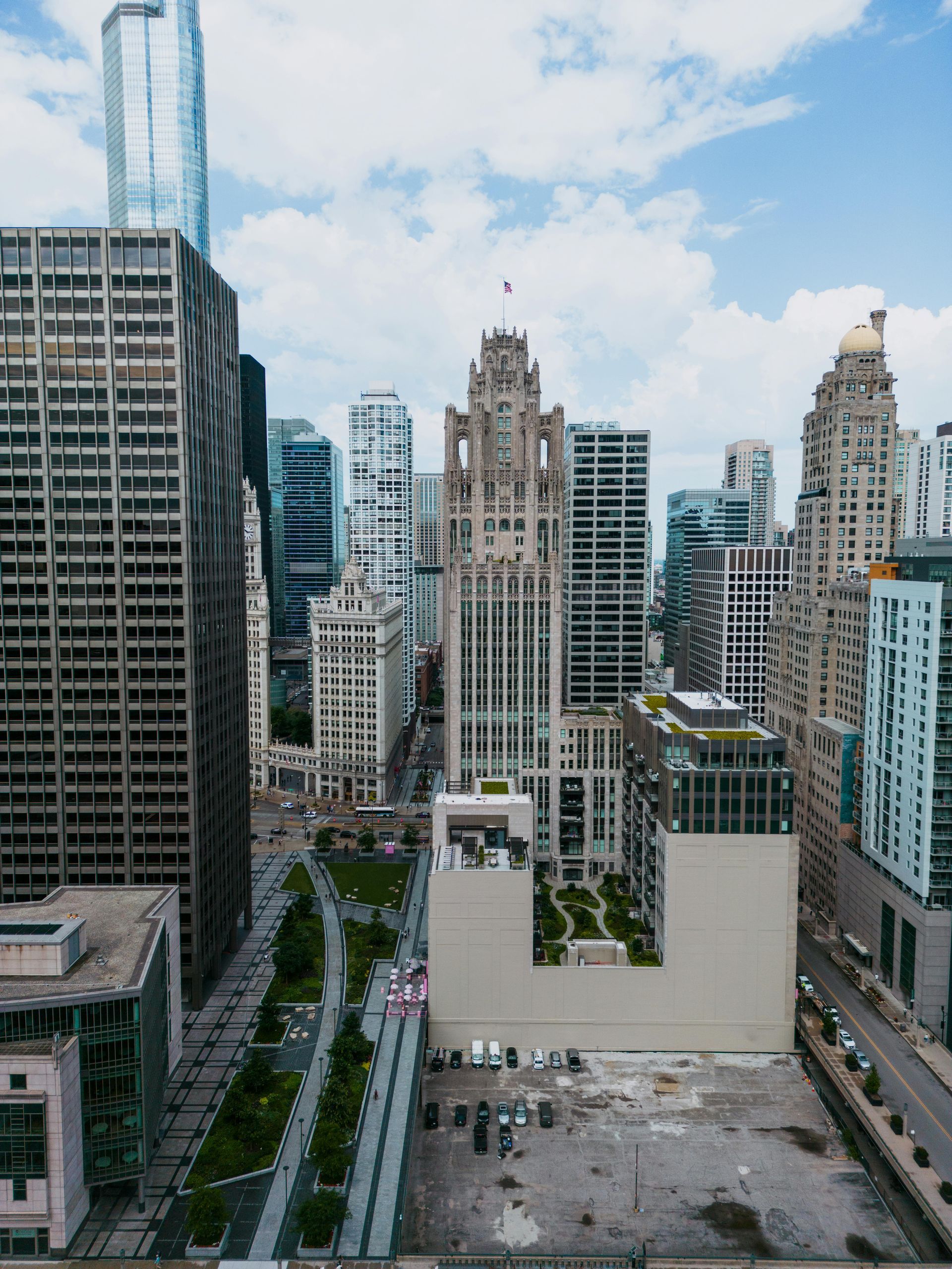Downtown skyline with tall office towers, a central tree-lined street, and a vacant lot in the foreground