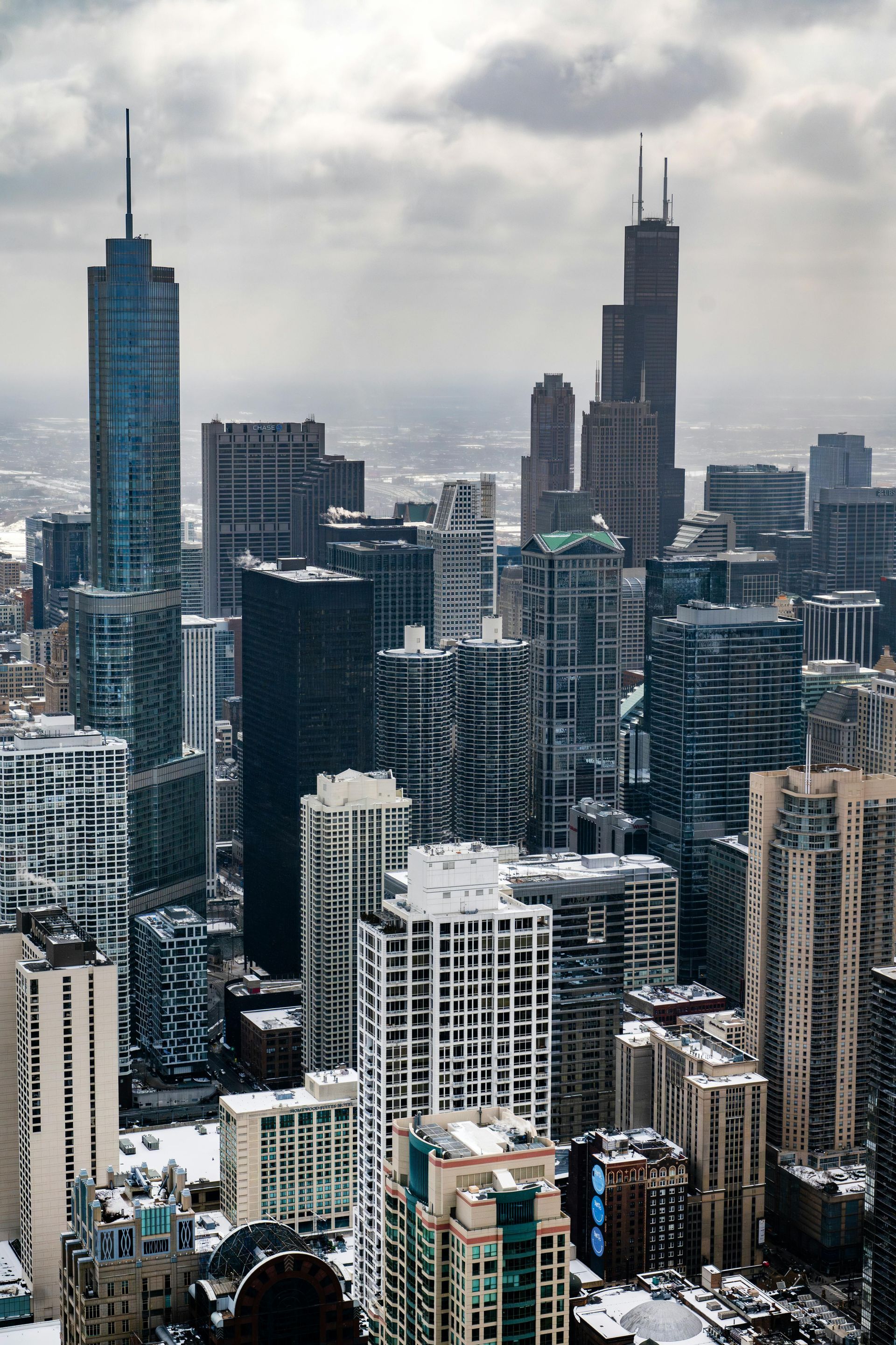 Snow-covered downtown skyline with tall skyscrapers under a cloudy sky