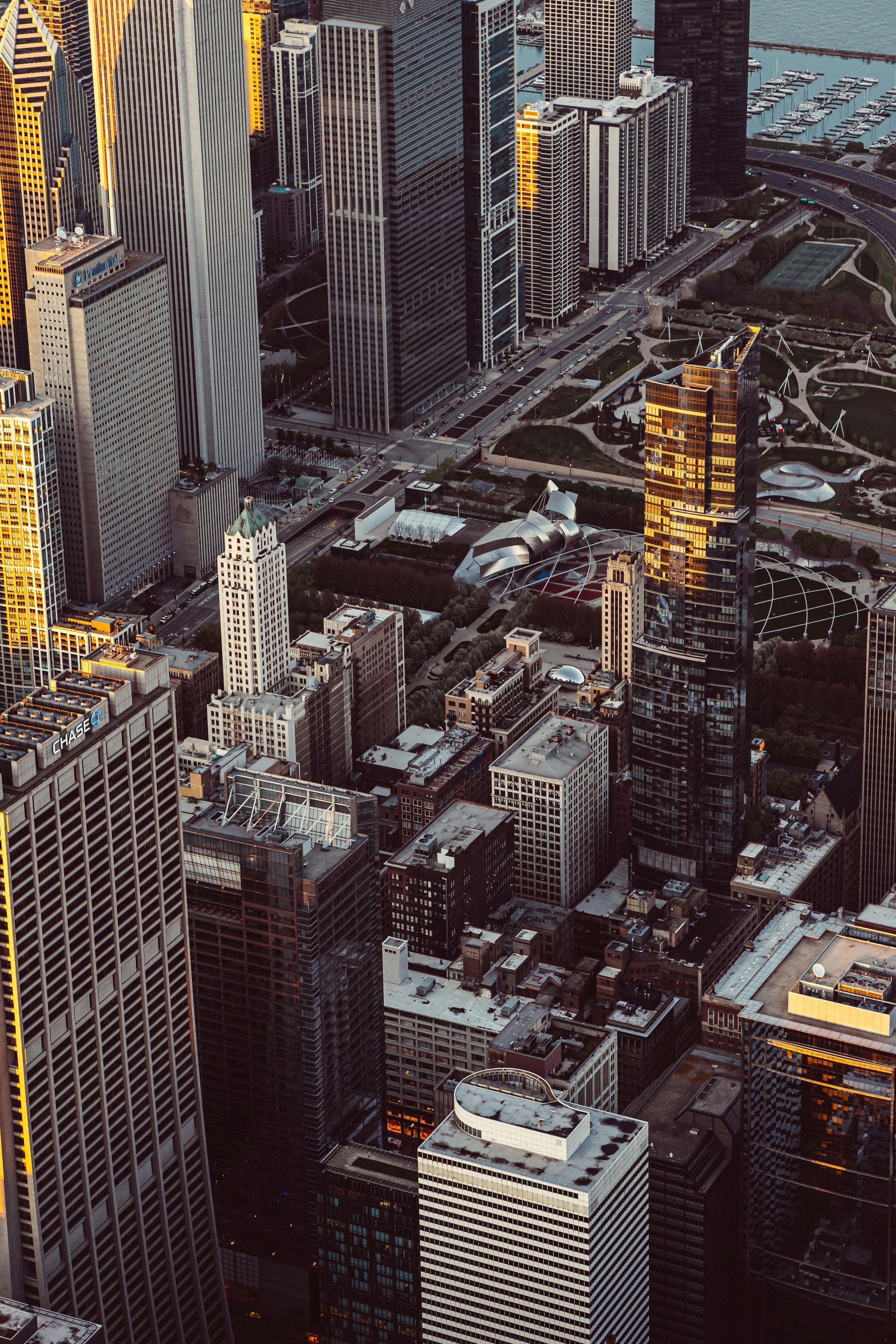 Aerial view of a dense city skyline with tall buildings and water in the background