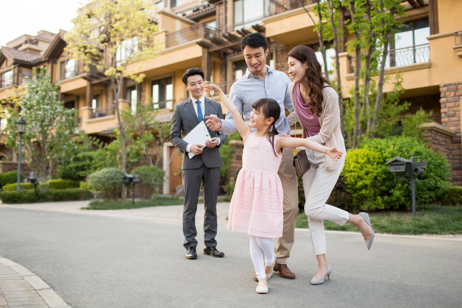 Family embracing in a bright entryway beside a front door and staircase