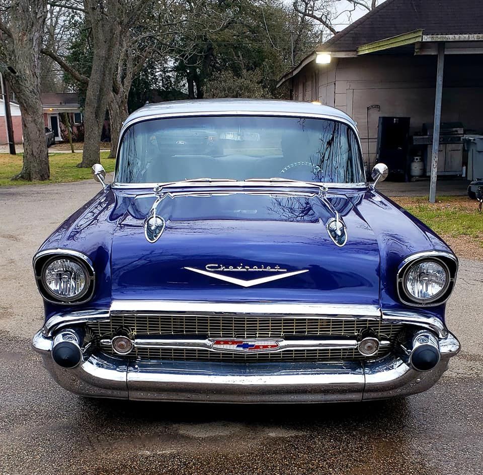 Blue 1957 Chevrolet Bel Air with chrome accents parked outdoors.