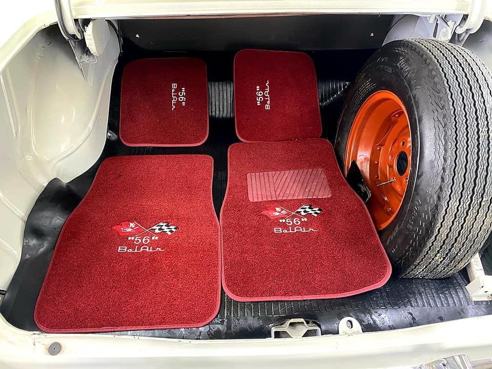 Red car floor mats and spare tire in a trunk.