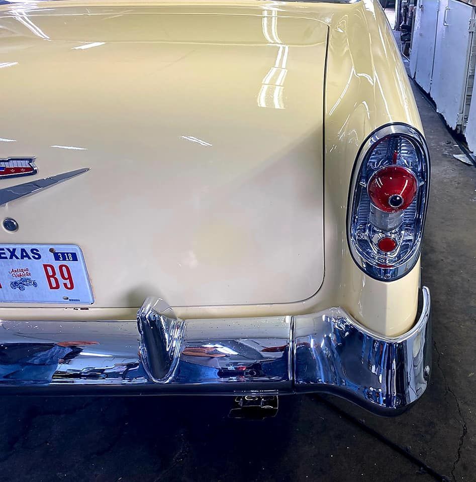 Rear of a light yellow vintage car with chrome accents and a Texas license plate.