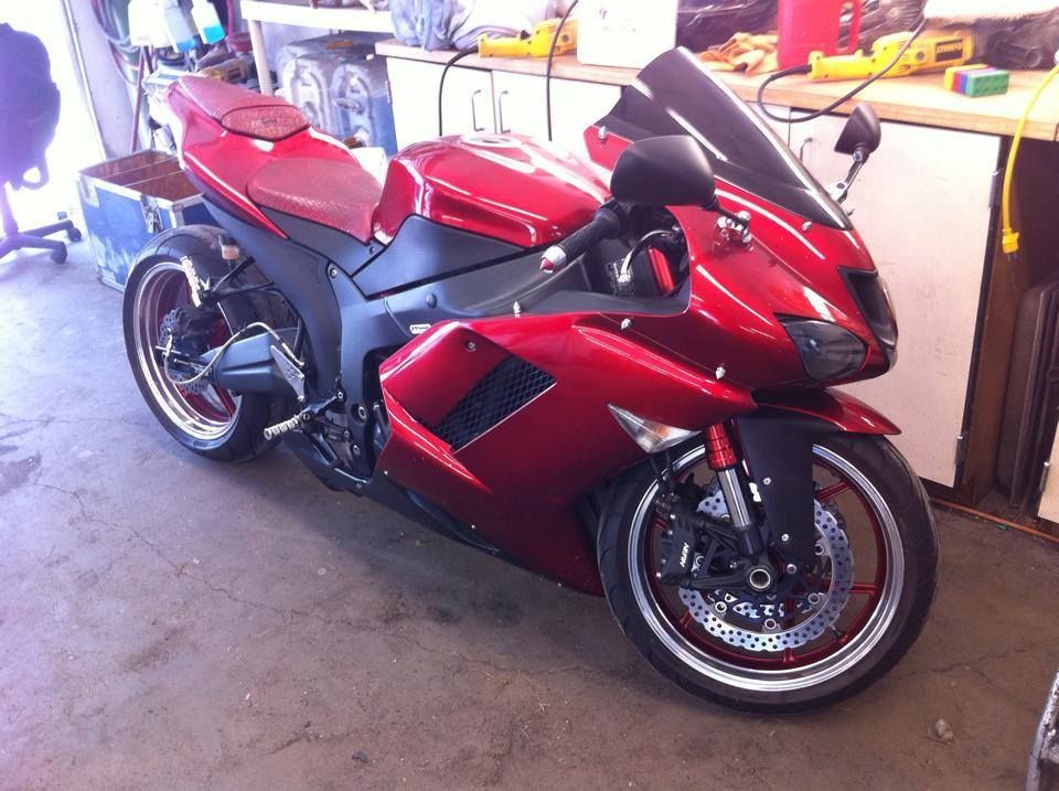 Red Kawasaki sport motorcycle parked in a garage.