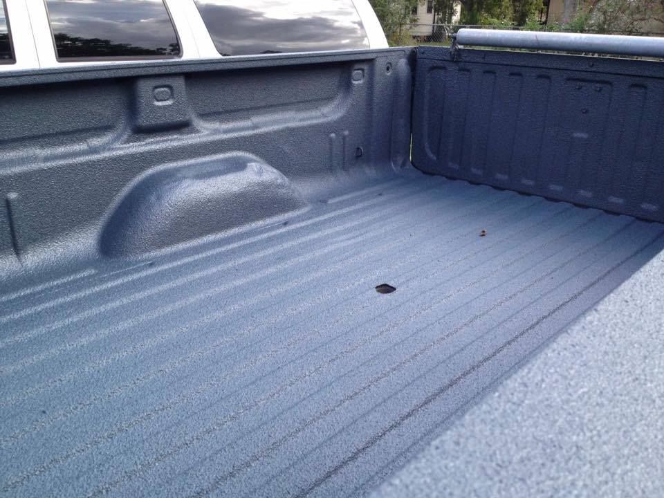 Blue truck bed interior with textured protective coating.