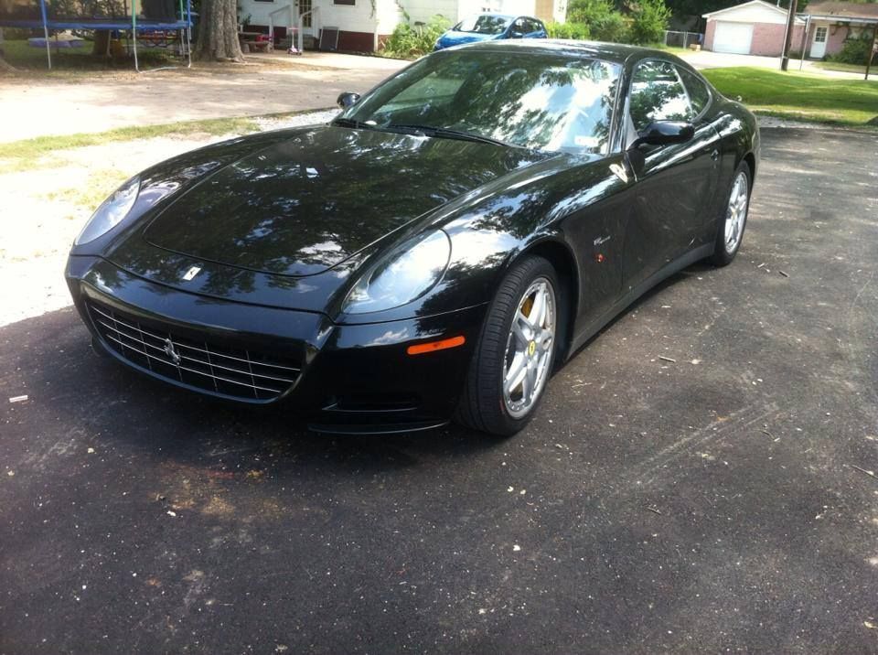 Black Ferrari coupe parked on asphalt.