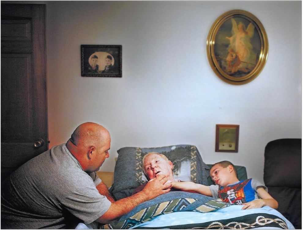 Jim Kennedy, prays with his father, William Hammond Kennedy, and Elijah Kennedy