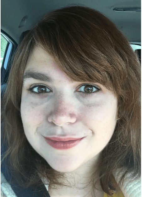 a woman with brown hair is smiling while sitting in a car 