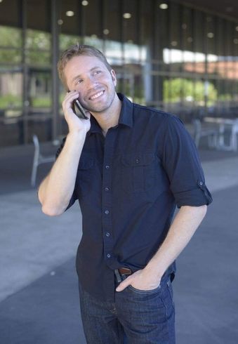 A man in a black shirt is talking on a cell phone