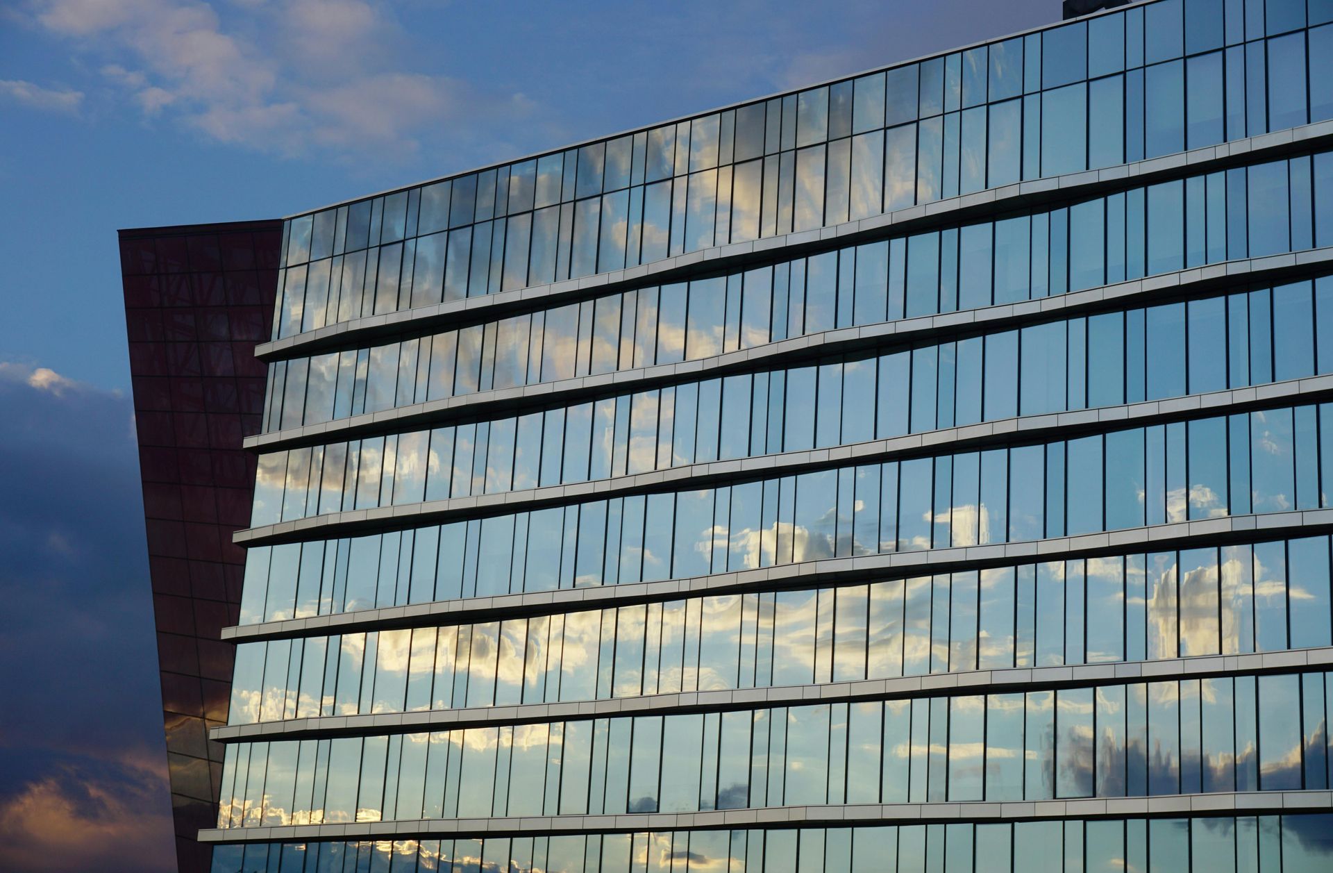 A large building with a lot of windows reflecting the sky