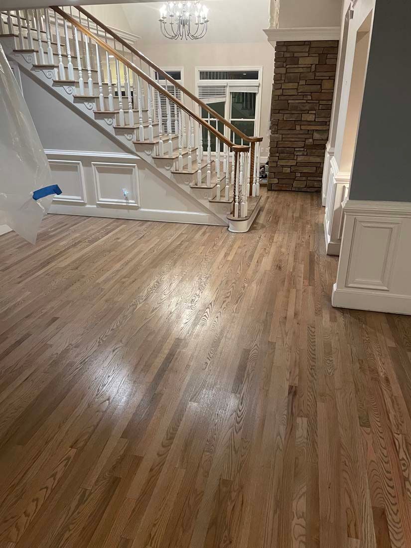 A living room with hardwood floors and a staircase.