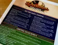 Restaurant catering menu for DeDe’s Pub & Grill with party platters and chopped salad bowls in black, blue, and orange print