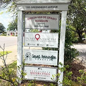 Sign listing businesses at 1305 Greensboro Avenue, including Jemison-Van de Graaff Mansion and Palmera Collective