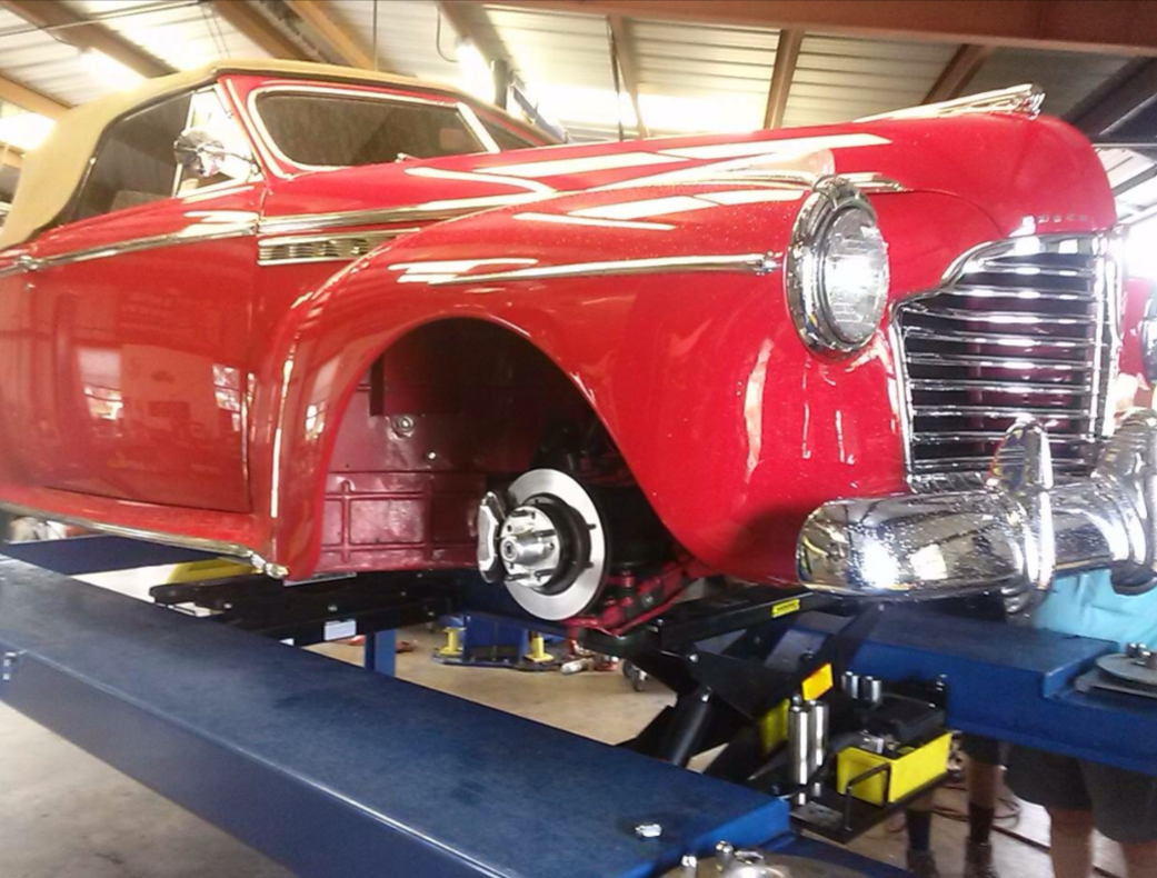 Red classic convertible car on a lift in a garage | Crown Car Care