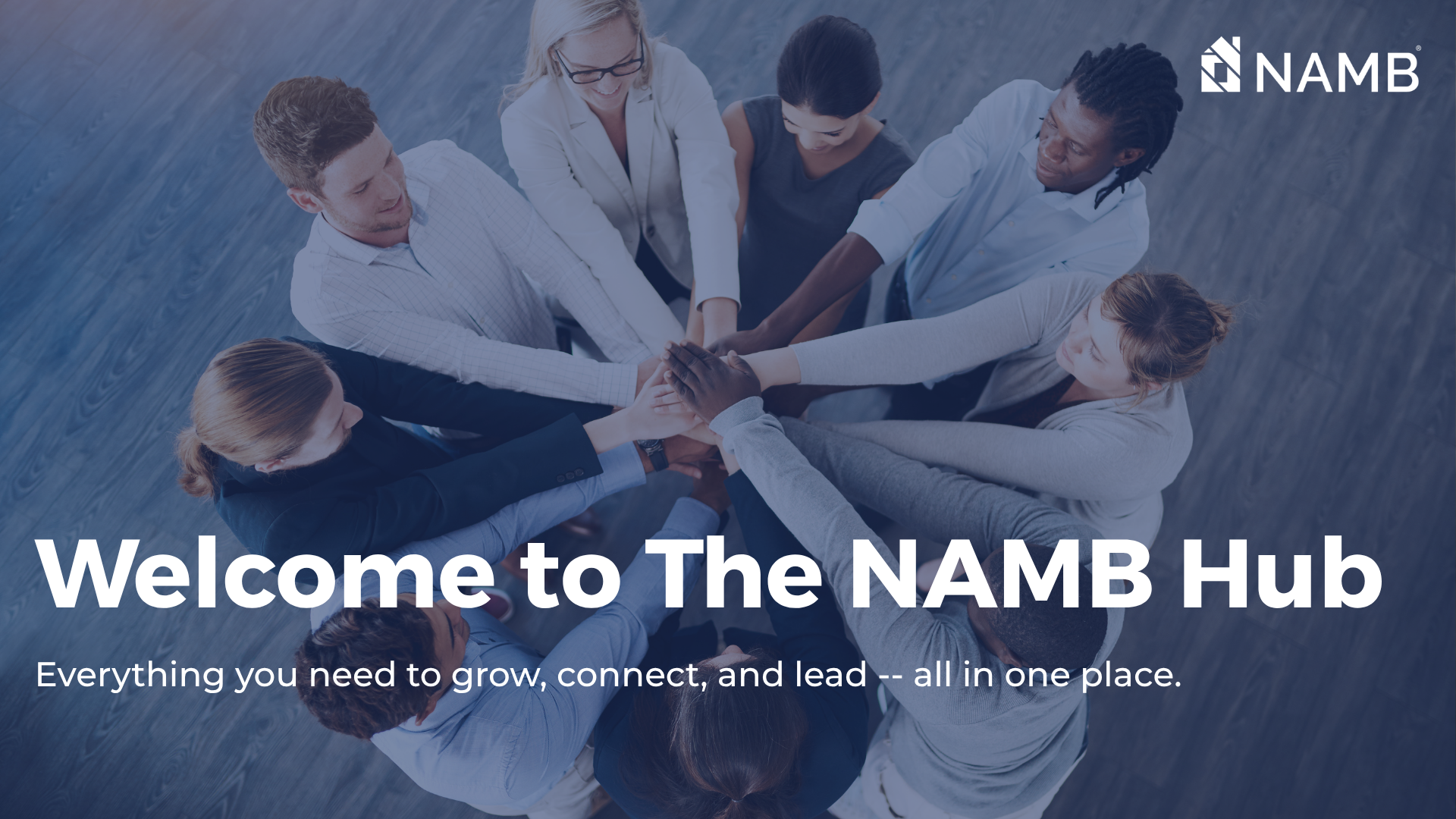 Team of people joining hands around a table with “Welcome to The NAMB Hub” text overlay