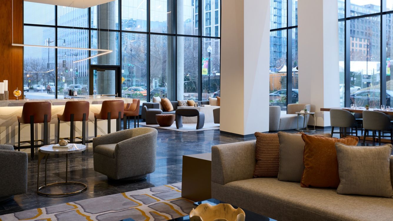 mc-wasnn-great-room-afternn-29314-20855_Wide-Hor Modern hotel lobby with large windows, lounge seating, and city views