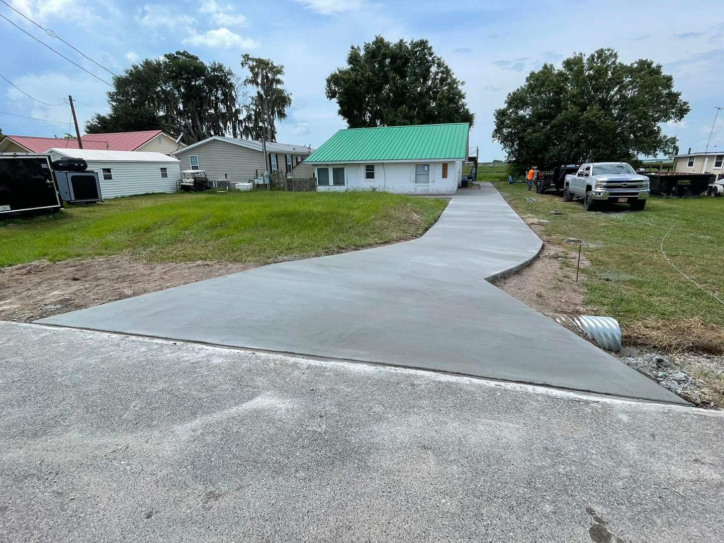 A concrete driveway is being built in front of a house.