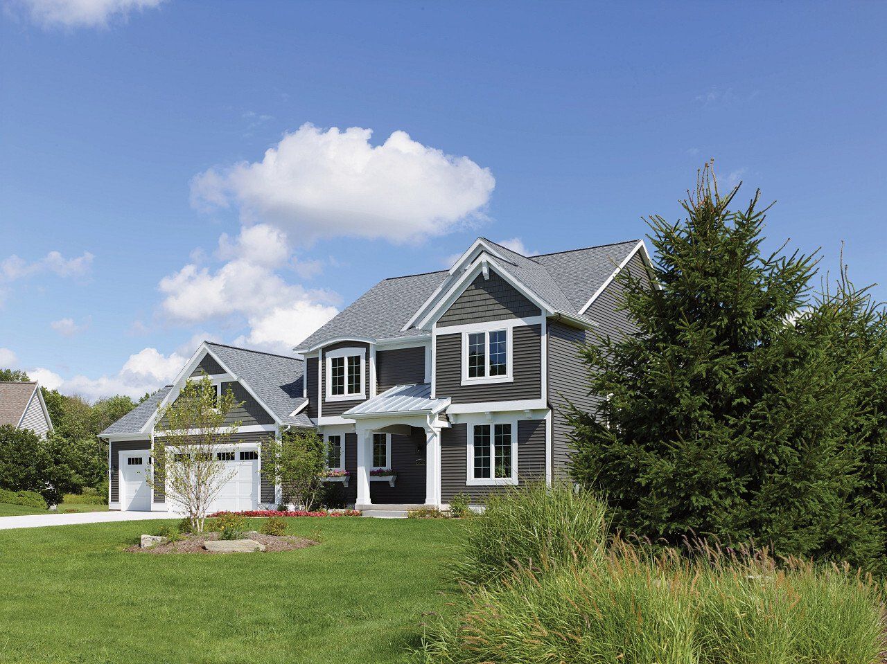 A large house is sitting on top of a lush green field.