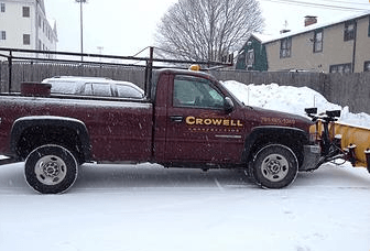 Maroon truck with snow plow owned by Crowell Construction used for Commercial Snow Removal