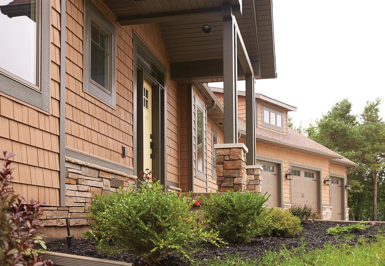 The front of a house with a porch and garages