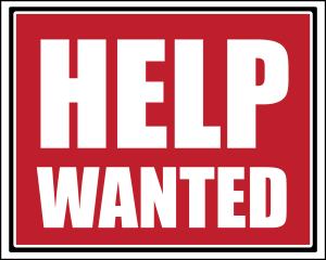A red sign that says help wanted in white letters