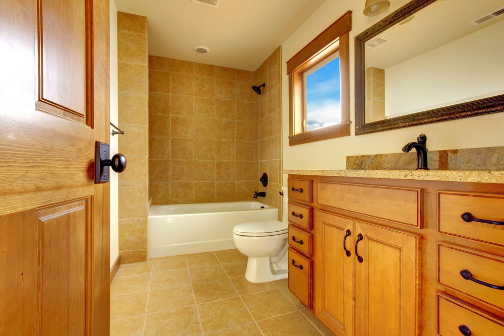 A bathroom with a toilet , sink , tub and mirror.