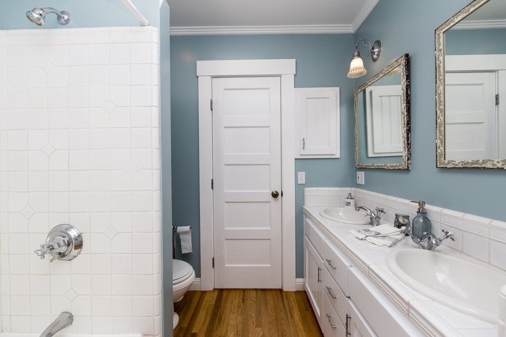 A bathroom with two sinks , a toilet , and a shower.