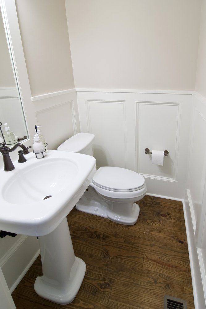 A bathroom with a toilet , sink and mirror