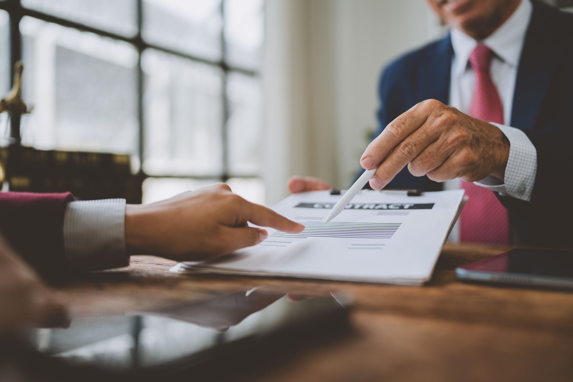 Business meeting with hands reviewing a document at a conference table