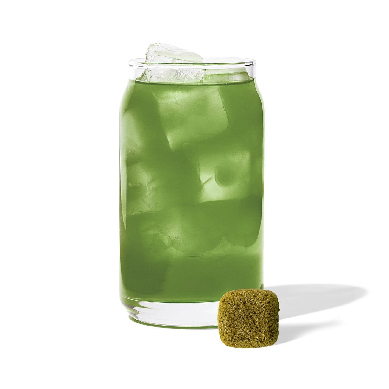 A single square matcha tea tablet placed above its small, lime green individual tea wrapper.