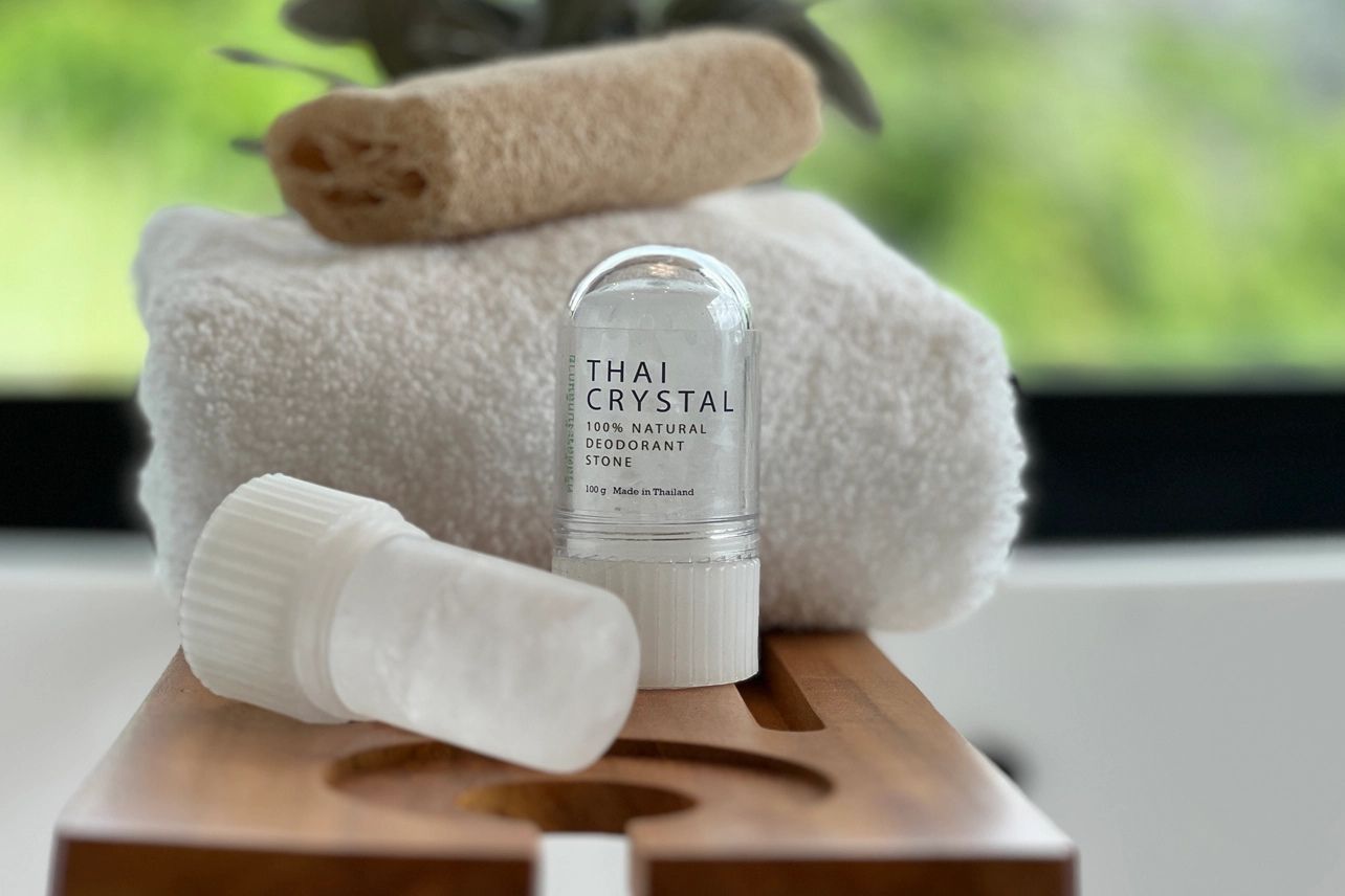 A Thai Crystal 100% natural deodorant stone standing next to its translucent, cylindrical cap.