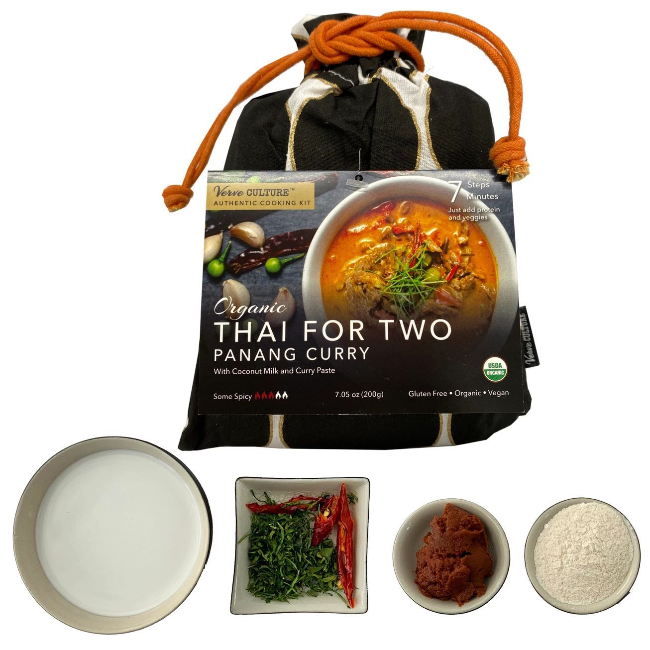 A black drawstring bag with white circles containing a Thai for Two Panang Curry meal kit against a dark grey background.