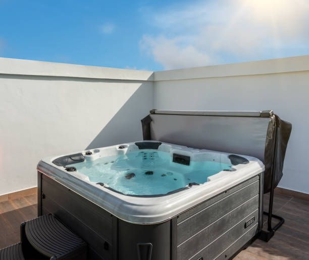 A hot tub is sitting on top of a wooden deck.
