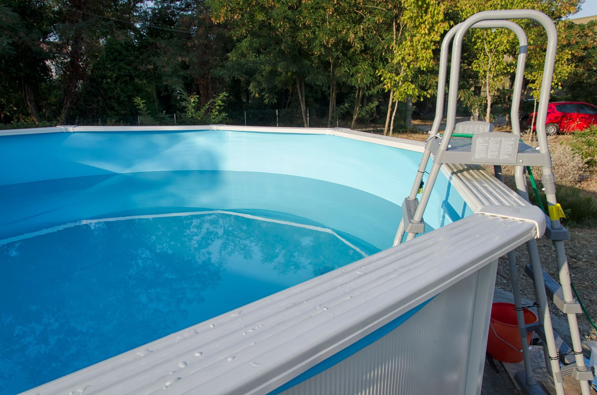 A swimming pool with a ladder attached to the side of it.
