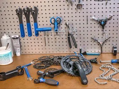 A table with a bunch of bicycle parts and tools on it