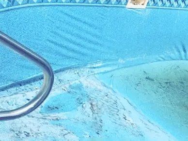 A close up of a swimming pool with a metal railing.