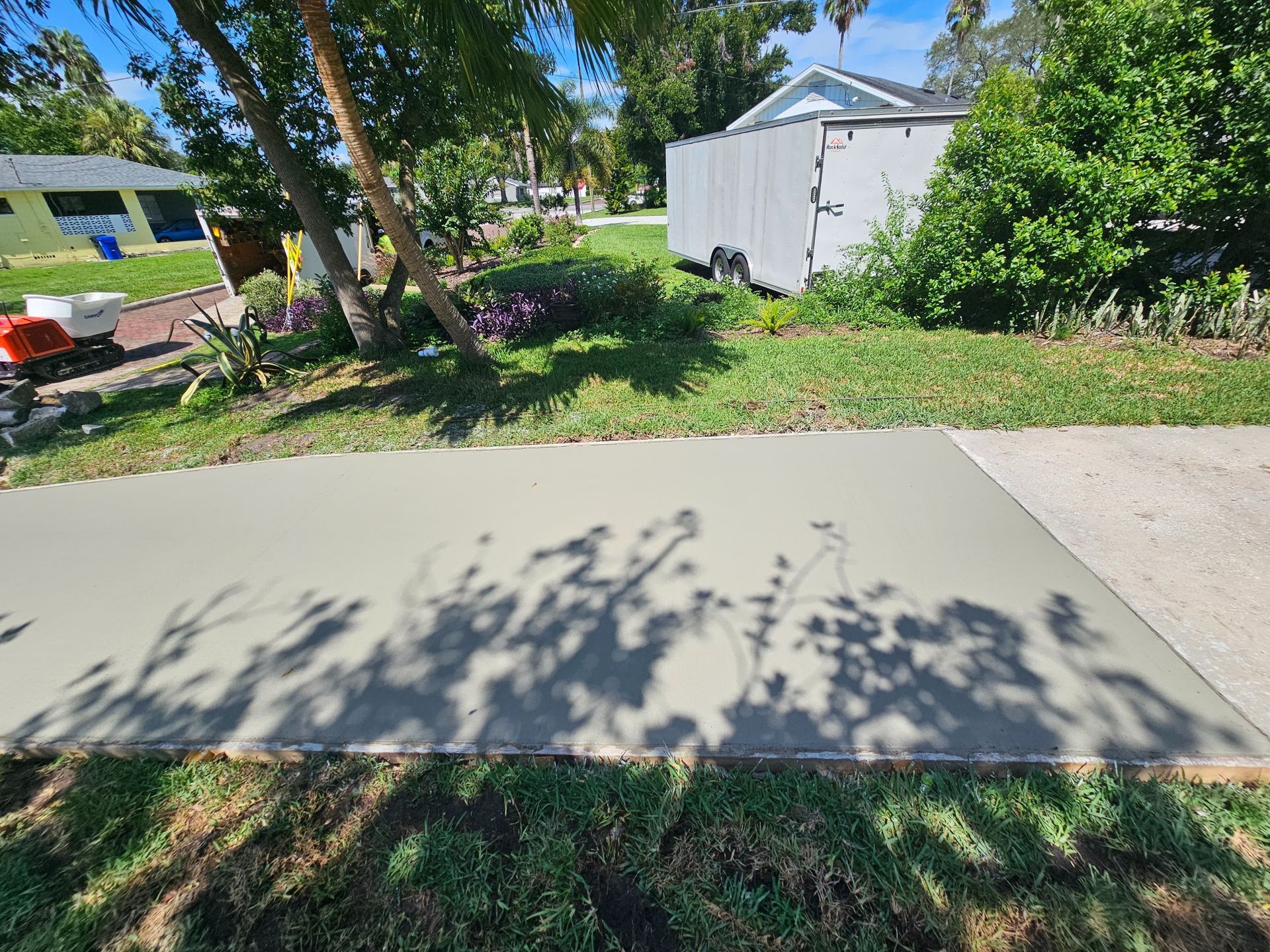 Freshly poured concrete slab with tree shadow.